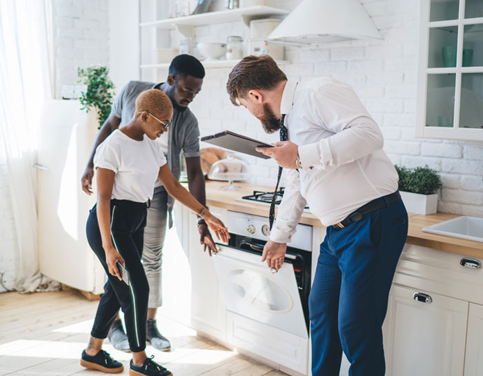 Family examining the stove in a house they're viewing with their realtor